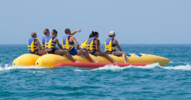 happy people having fun on banana boat